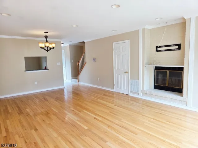 a view of an empty room with a kitchen and a window