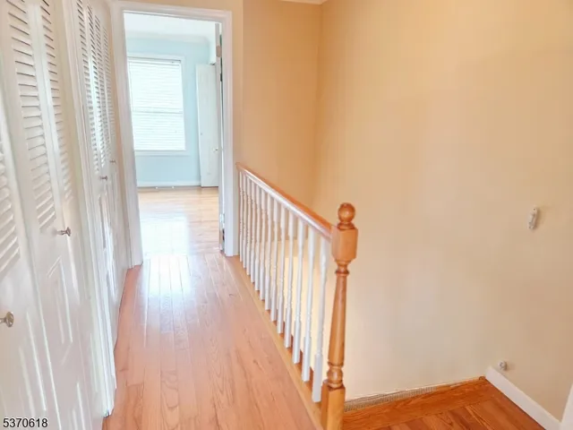 a view of a hallway with wooden floor and entryway