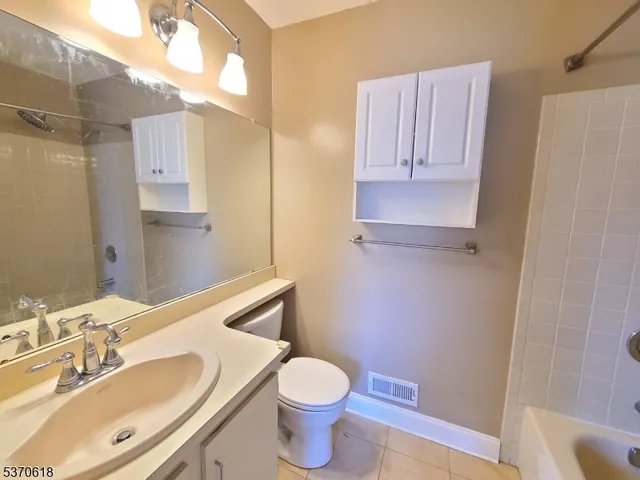 a bathroom with a granite countertop toilet sink and mirror