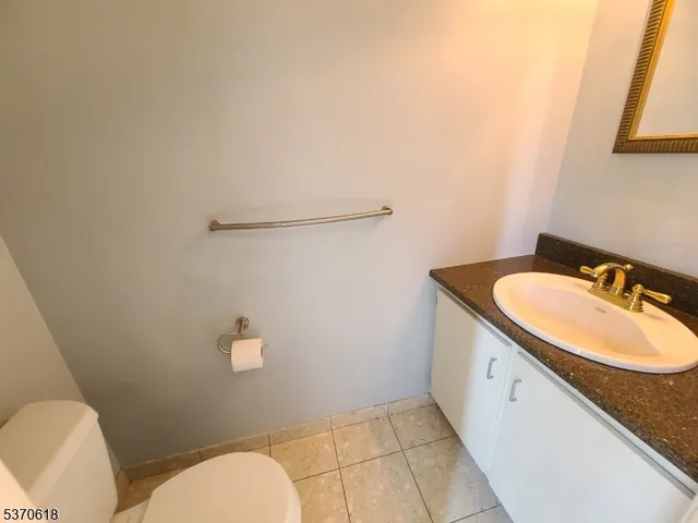 a bathroom with a granite countertop sink mirror vanity and toilet