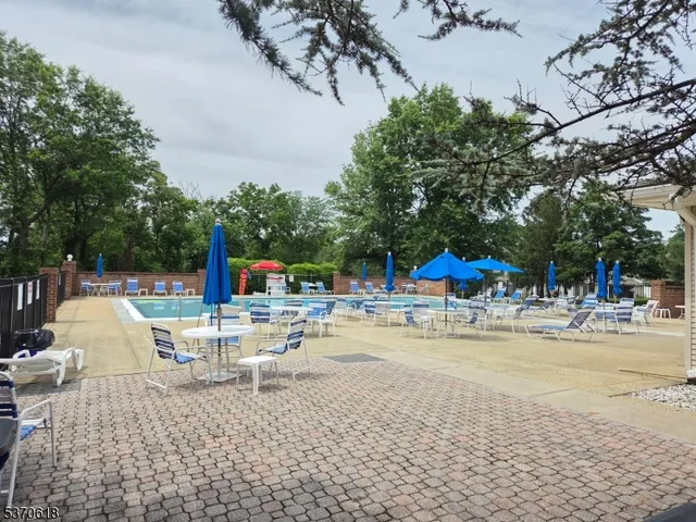 a view of a swimming pool with a table and chairs under an umbrella