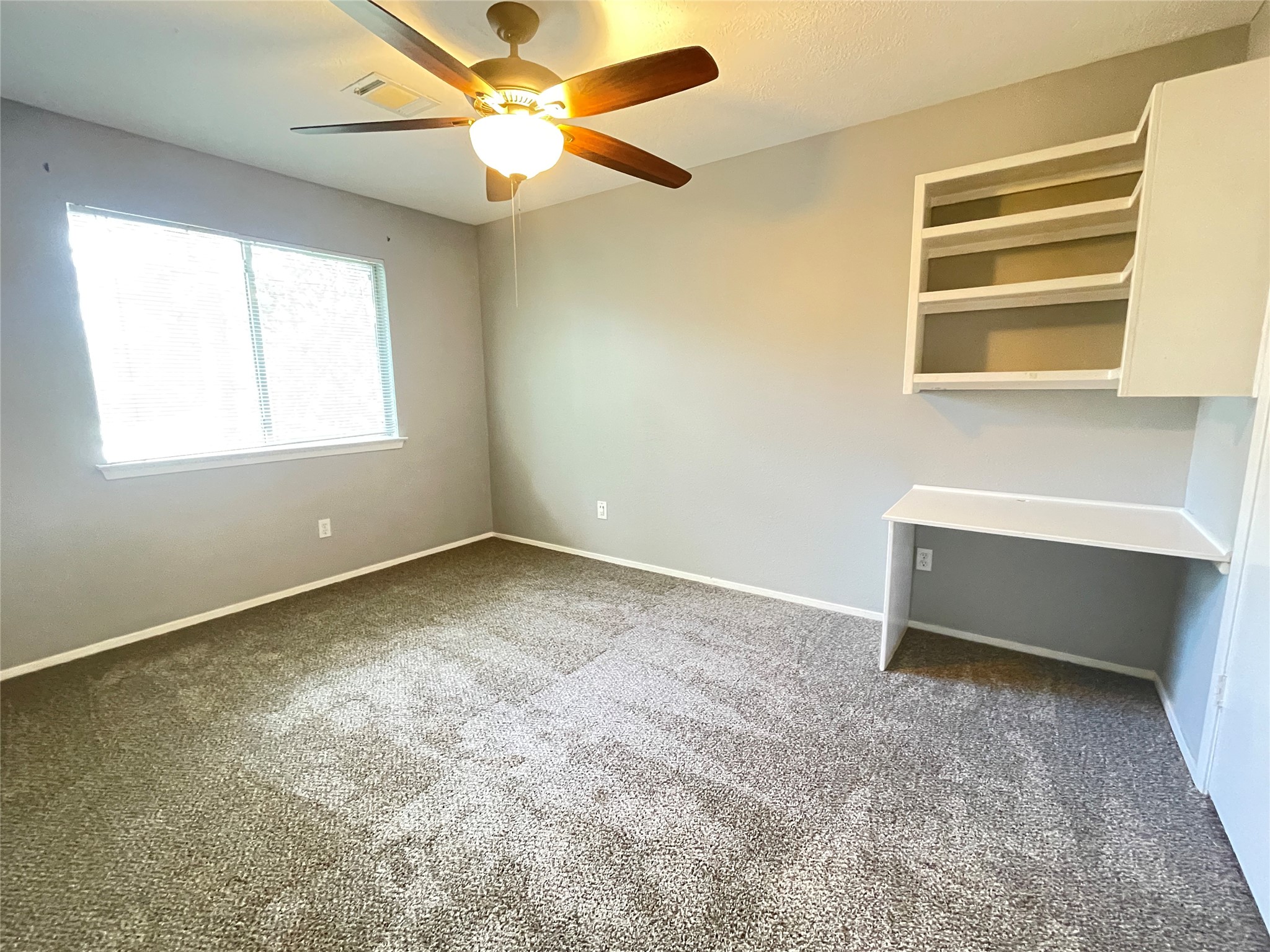 5006 Temple Bell Drive Spring, TX 77388 - Photo 17 of 27 Secondary bedroom 1 featuring built-in desk and shelves