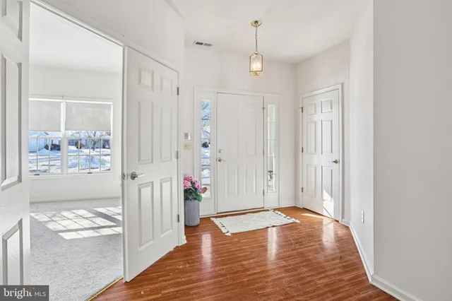 a hallway with wooden floor table and chairs