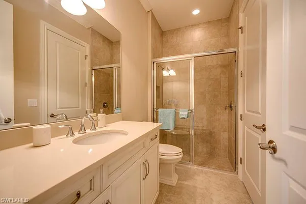 a bathroom with a double vanity sink toilet mirror and shower