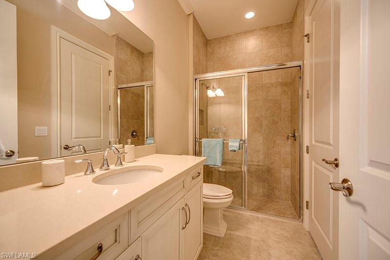 6564 Roma Way Naples, FL 34113 - Photo 17 of 22 a bathroom with a double vanity sink toilet mirror and shower