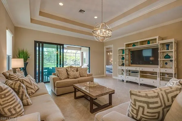 a living room with furniture ceiling fan and a flat screen tv
