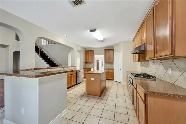 a kitchen with a stove sink and cabinets