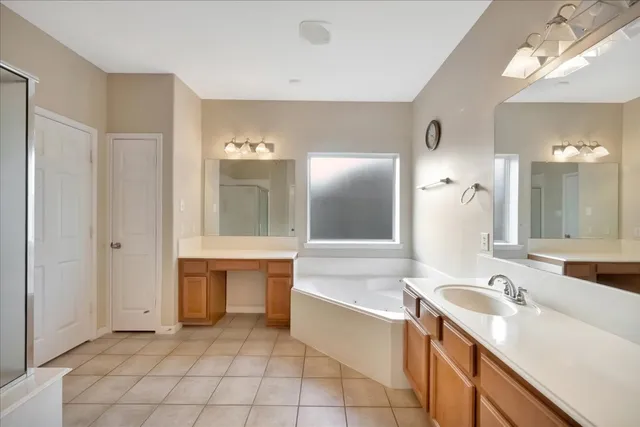 a bathroom with a tub sink and mirror