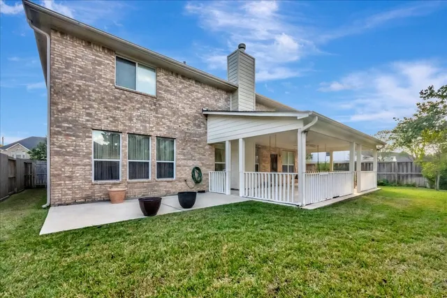 a view of a house with a small yard and wooden fence