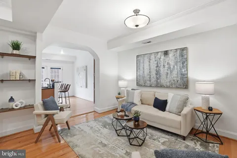 a living room with furniture a rug and wall painting