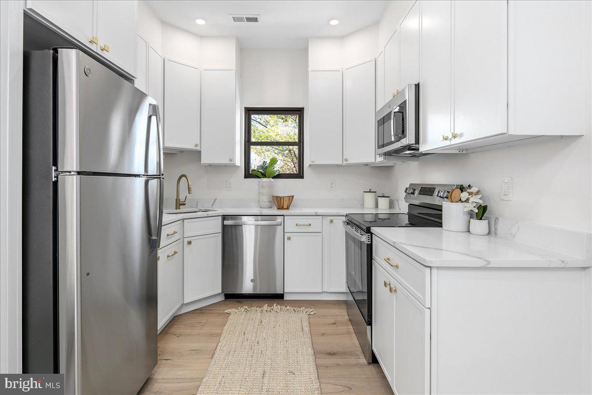 21 Channing Street Northeast Washington, DC 20002 - Photo 37 of 48 a kitchen with white cabinets sink and white stainless steel appliances