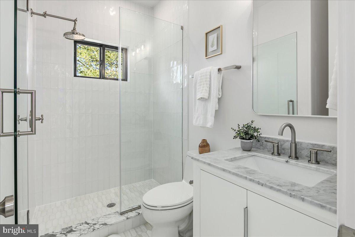 21 Channing Street Northeast Washington, DC 20002 - Photo 41 of 48 a bathroom with a granite countertop sink a toilet and shower