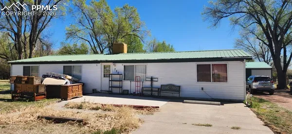 a front view of a house with a yard covered with snow in front of house