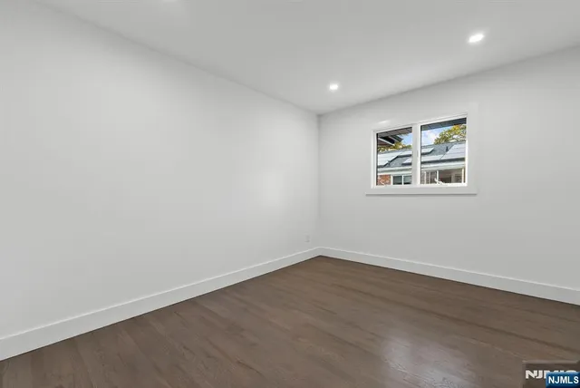 an empty room with wooden floor & closet area