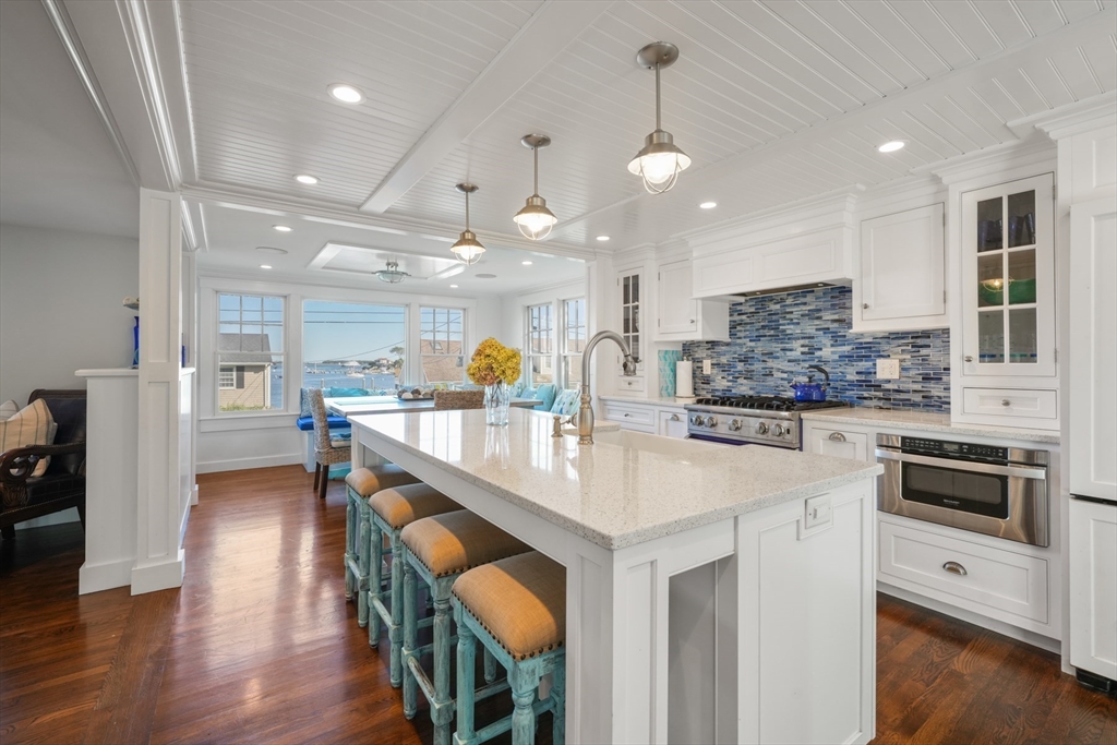 29 Bay Shore Road Hyannis, MA 02601 - Photo 7 of 42 a kitchen with stainless steel appliances kitchen island granite countertop a table chairs in it and wooden floors
