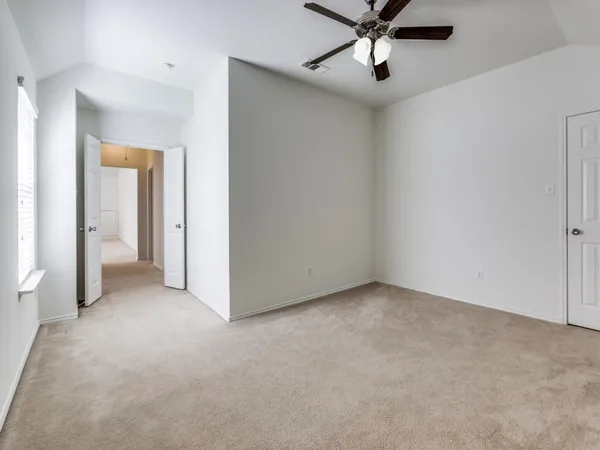 an empty room with a ceiling fan and a window