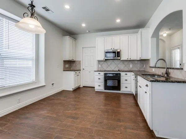 a kitchen with stainless steel appliances granite countertop a stove a sink and a refrigerator