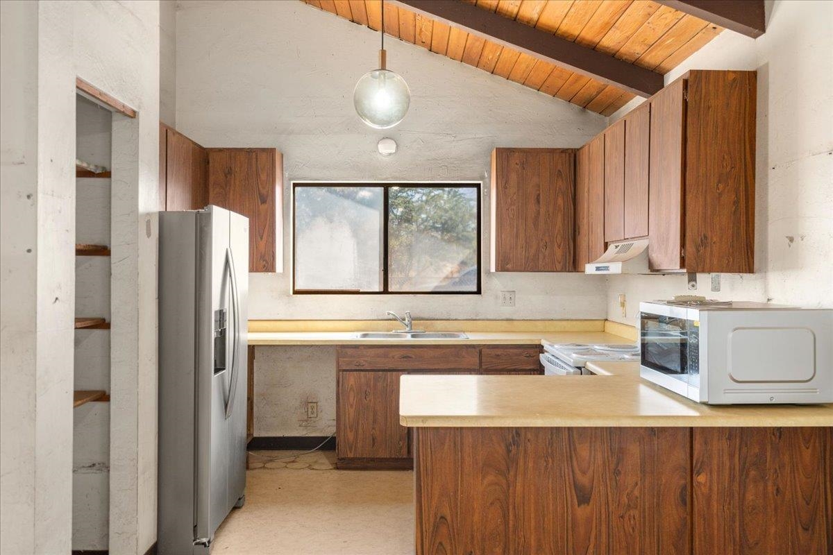 2040 Kanakanui Road Kihei, HI 96753 - Photo 5 of 22 a kitchen with stainless steel appliances granite countertop a sink and a refrigerator