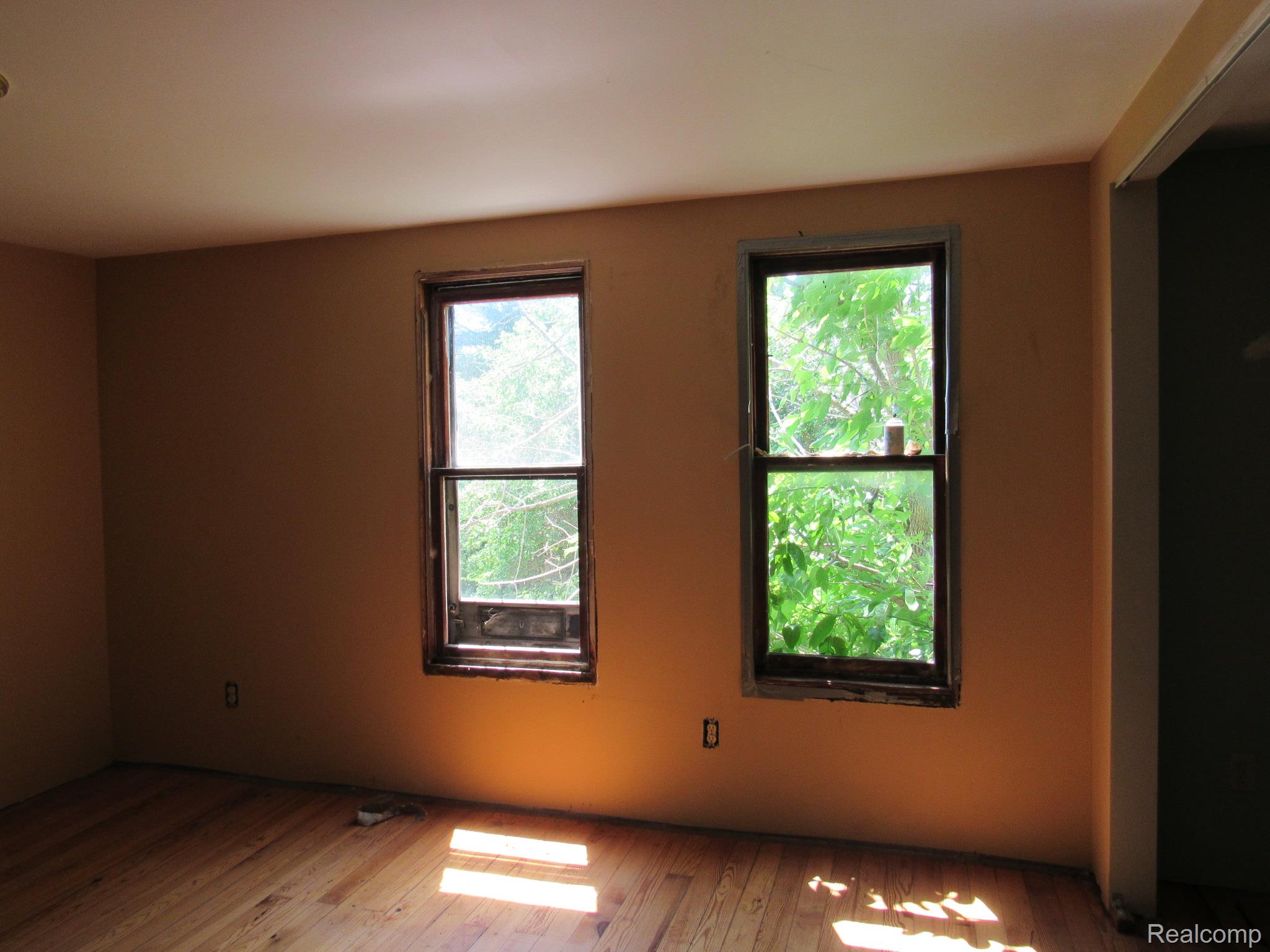 695 Cass Avenue Road Bay City, MI 48708 - Photo 25 of 52 Room featuring two single-hung windows, light wood-finish flooring, and a neutral wall color
