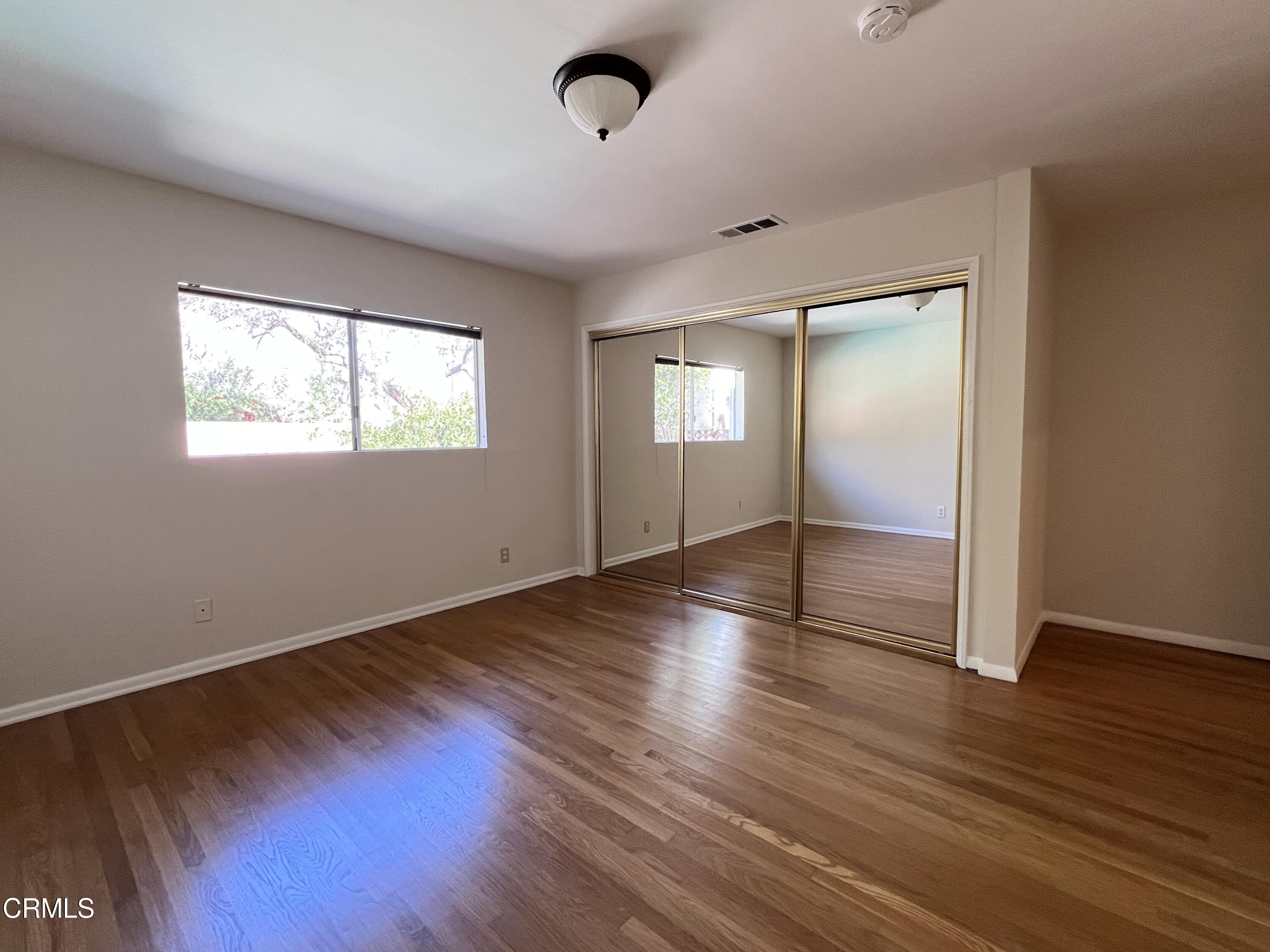 3159 Piccolo Street Pasadena, CA 91107 - Photo 9 of 14 an empty room with wooden floor and windows