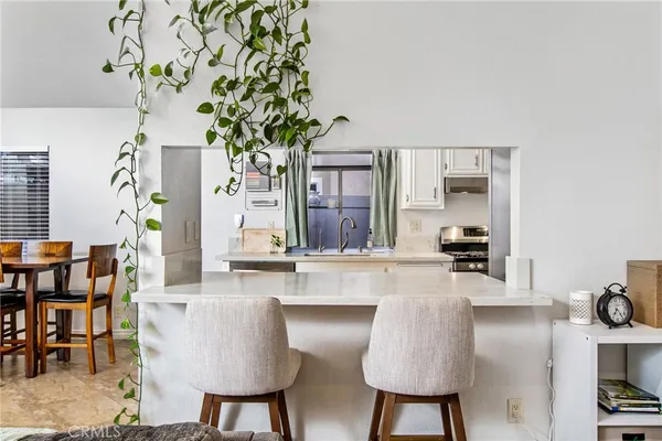 a kitchen with stainless steel appliances granite countertop a table and chairs in it