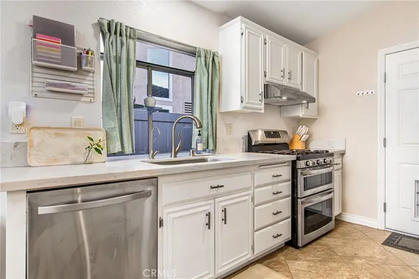 a kitchen with cabinets appliances and a window