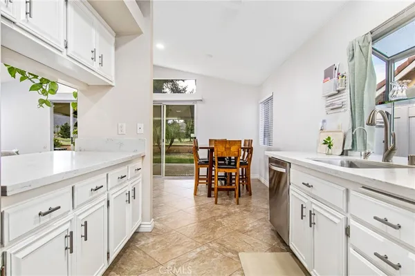 a kitchen with white cabinets and sink