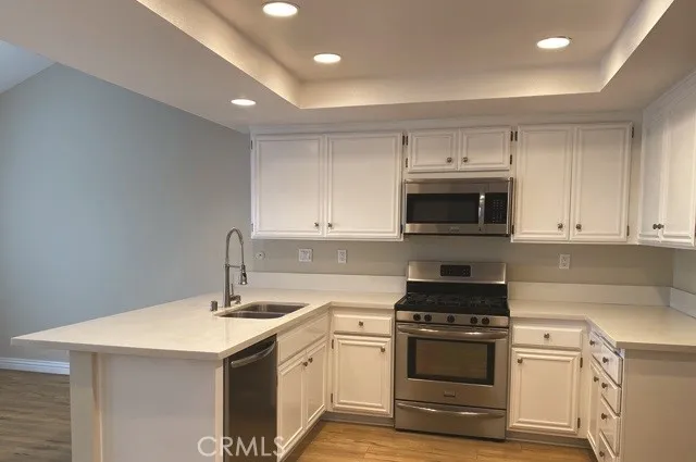 a kitchen with sink a microwave and cabinets