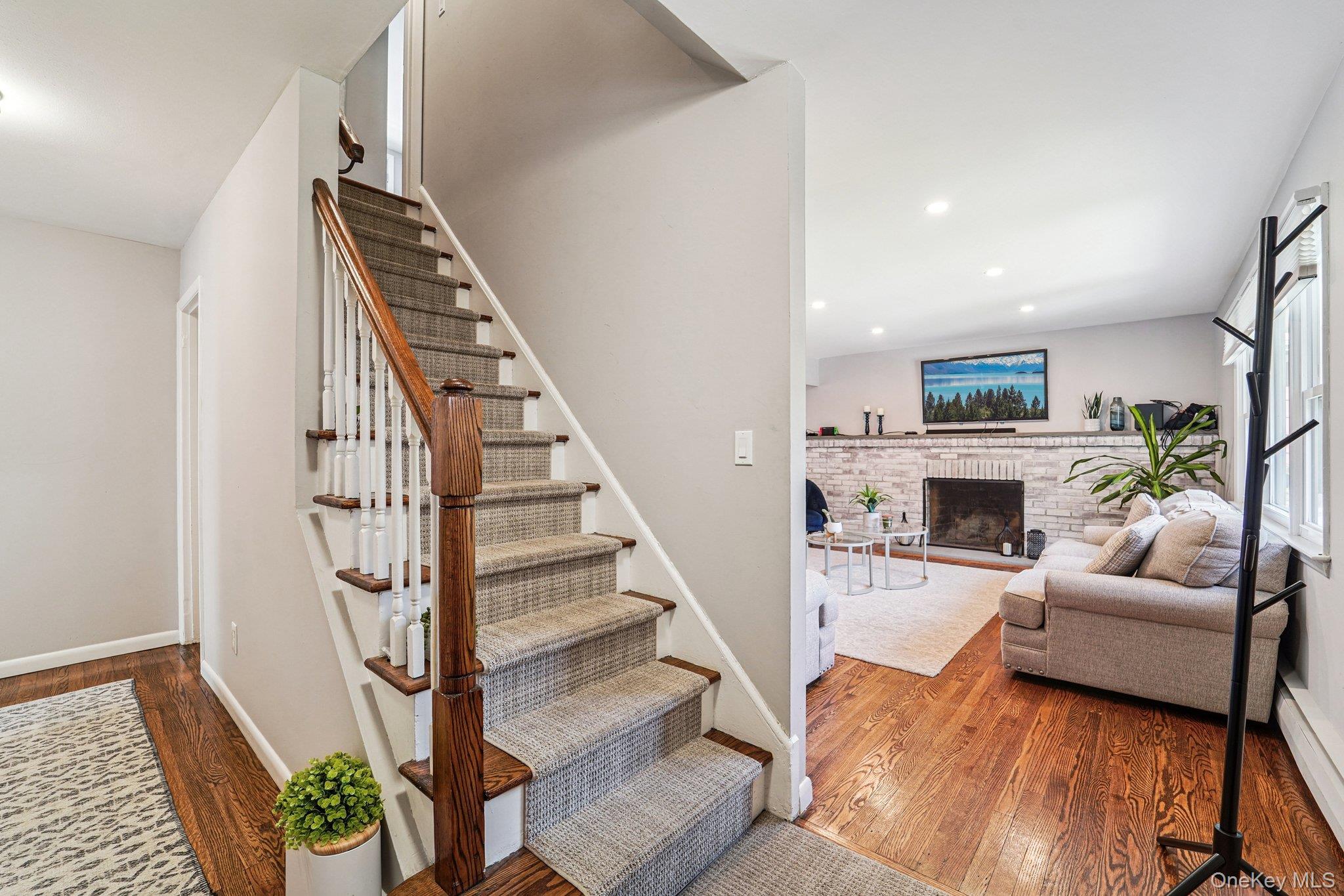 252 County Center Road White Plains, NY 10603 - Photo 12 of 44 Stairs featuring hardwood / wood-style flooring, a baseboard heating unit, a fireplace, and recessed lighting