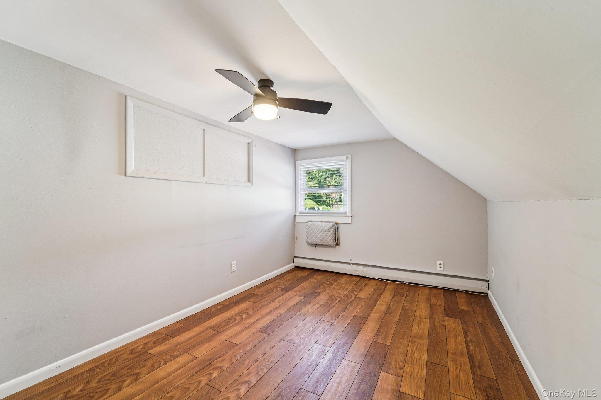 252 County Center Road White Plains, NY 10603 - Photo 20 of 44 Bonus room featuring hardwood / wood-style floors, a baseboard radiator, vaulted ceiling, a wall mounted AC, and a ceiling fan