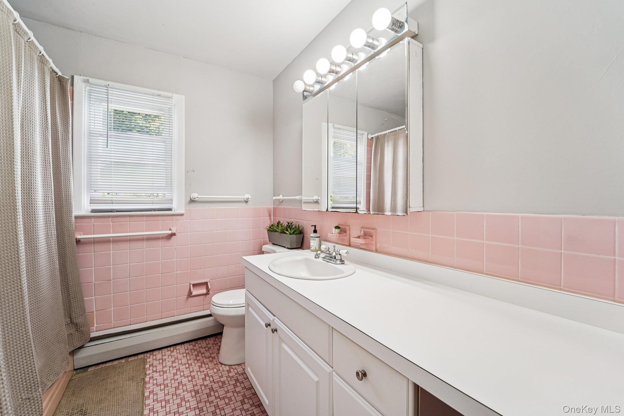 252 County Center Road White Plains, NY 10603 - Photo 28 of 44 Full bathroom with a baseboard heating unit, vanity, tile walls, wainscoting, and light tile patterned floors