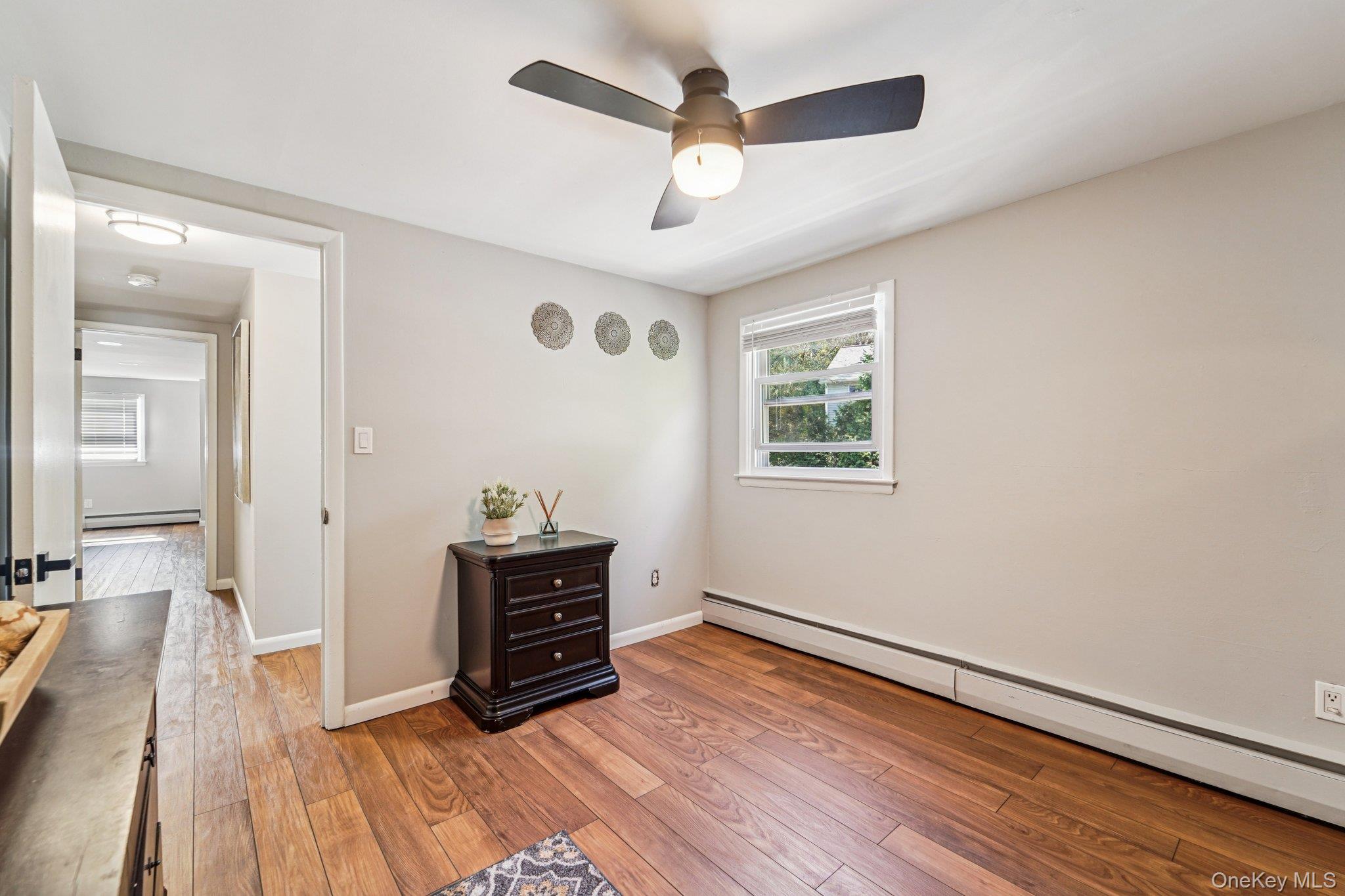 252 County Center Road White Plains, NY 10603 - Photo 30 of 44 Spare room with a baseboard radiator, light wood-style floors, and a ceiling fan