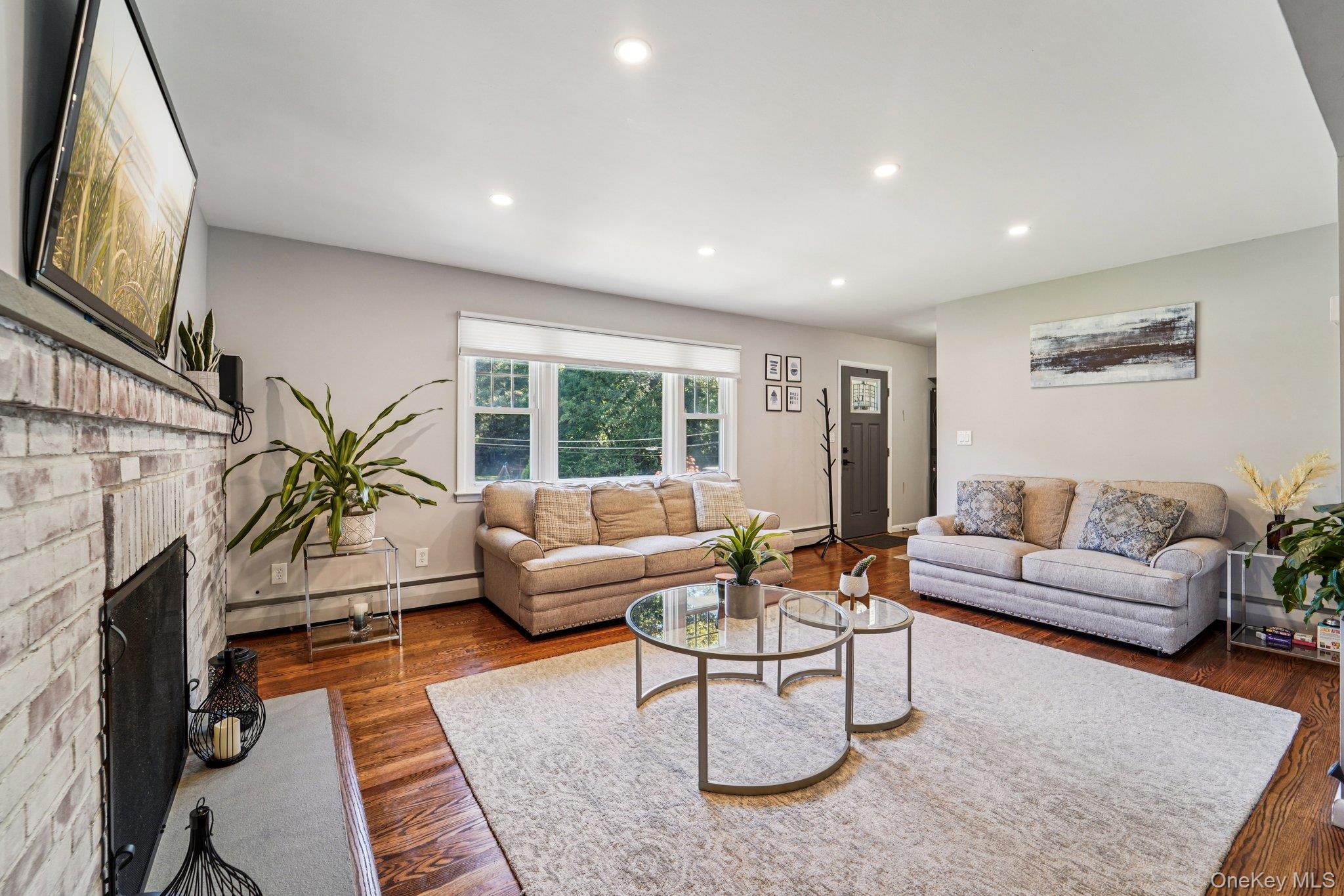 252 County Center Road White Plains, NY 10603 - Photo 3 of 44 Living room with recessed lighting, a baseboard radiator, dark wood-style flooring, and a brick fireplace