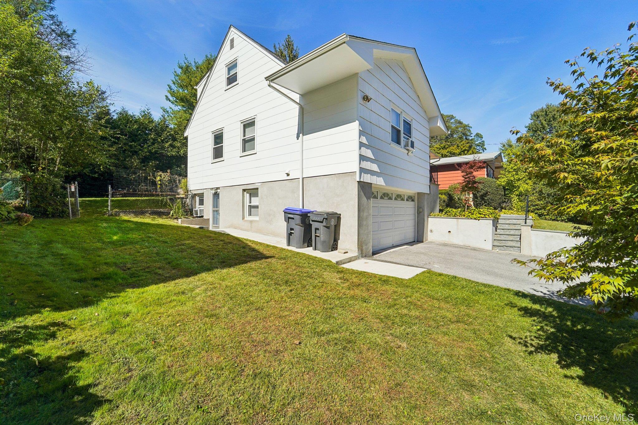 252 County Center Road White Plains, NY 10603 - Photo 35 of 44 Back of property with driveway, an attached garage, and stucco siding