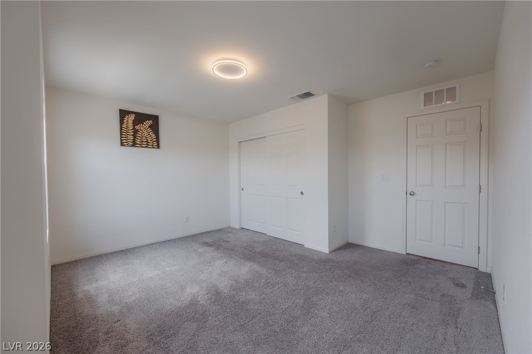 5927 Coja Street Las Vegas, NV 89113 - Photo 27 of 32 Unfurnished bedroom with carpet floors, a closet, and baseboards
