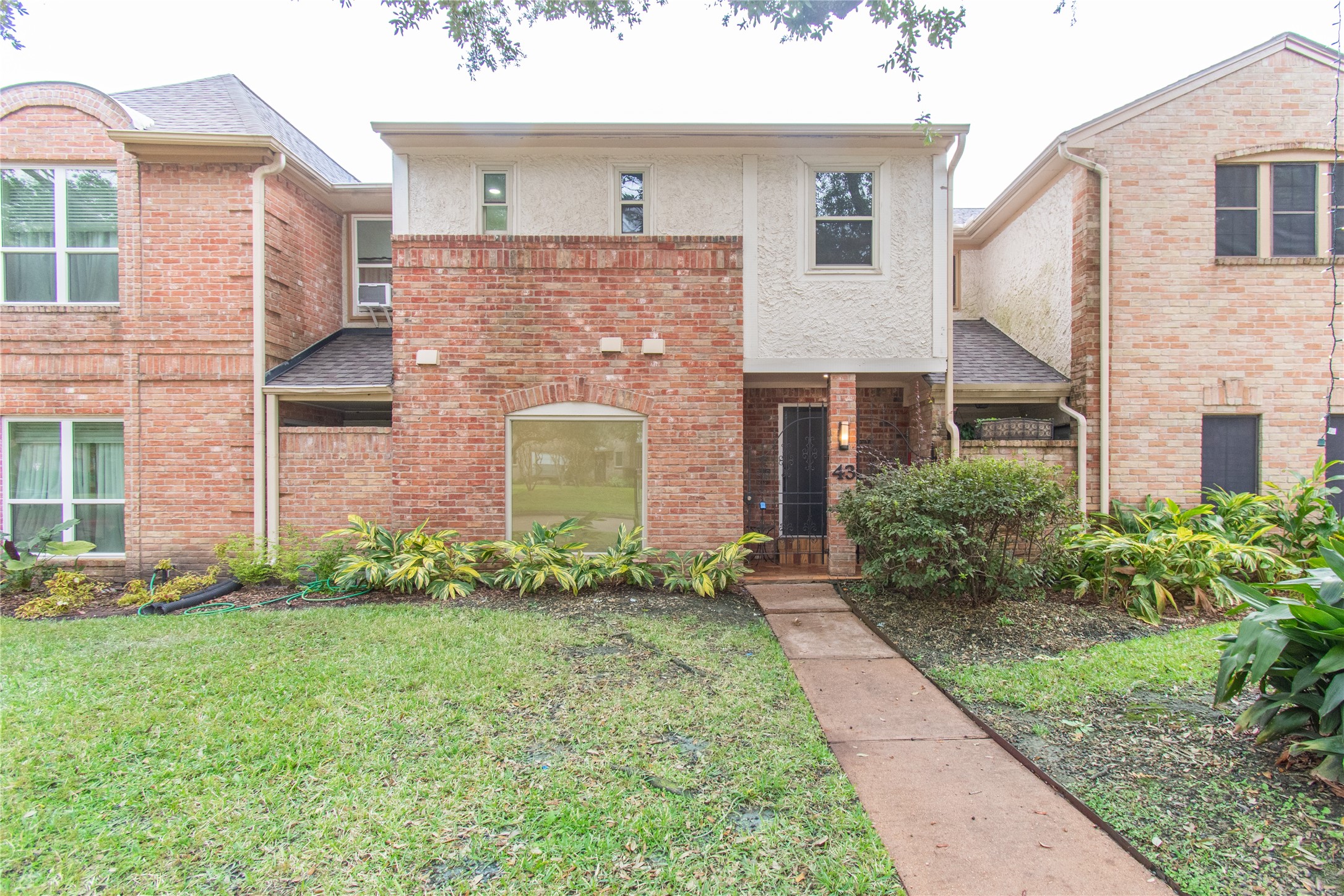 727 Bunker Hill Road, Unit 43 Houston, TX 77024 - Photo 2 of 34 The house is nestled between similar brick homes, offering a cozy neighborhood feel.