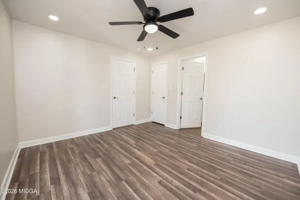 a view of empty room with wooden floor
