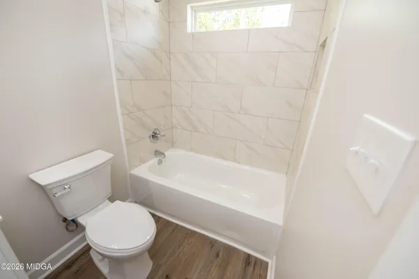a white toilet sitting next to a bath tub
