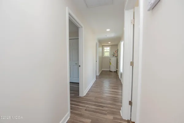 a view of a hallway with wooden floor