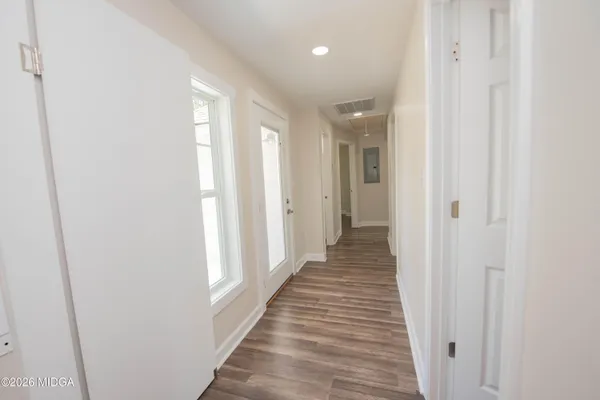 a view of a hallway with wooden floor