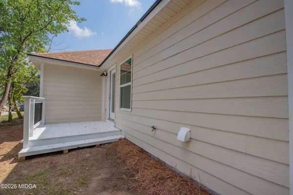a view of house with backyard and seating area