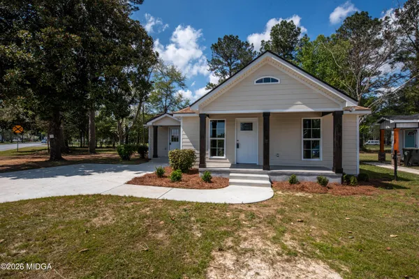 a front view of a house with sitting area and garden