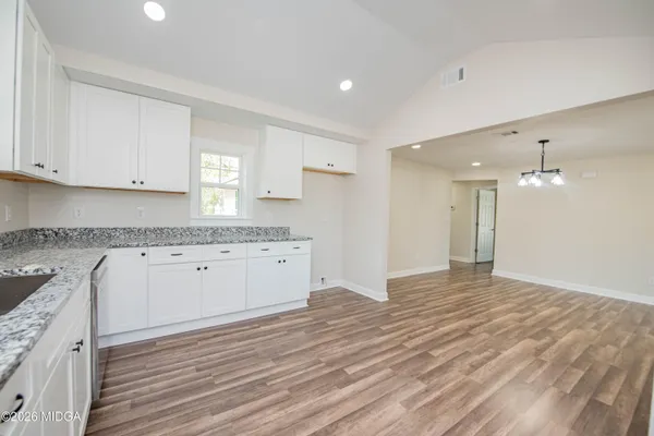 a view of kitchen with granite countertop cabinets and wooden floor