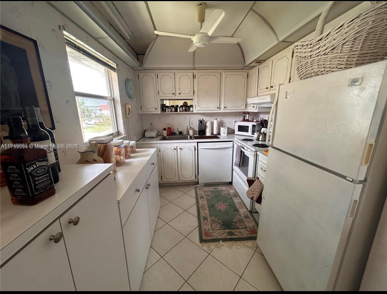 92 Saxony B, Unit B Delray Beach, FL 33446 - Photo 4 of 9 a kitchen with a sink a refrigerator and cabinets