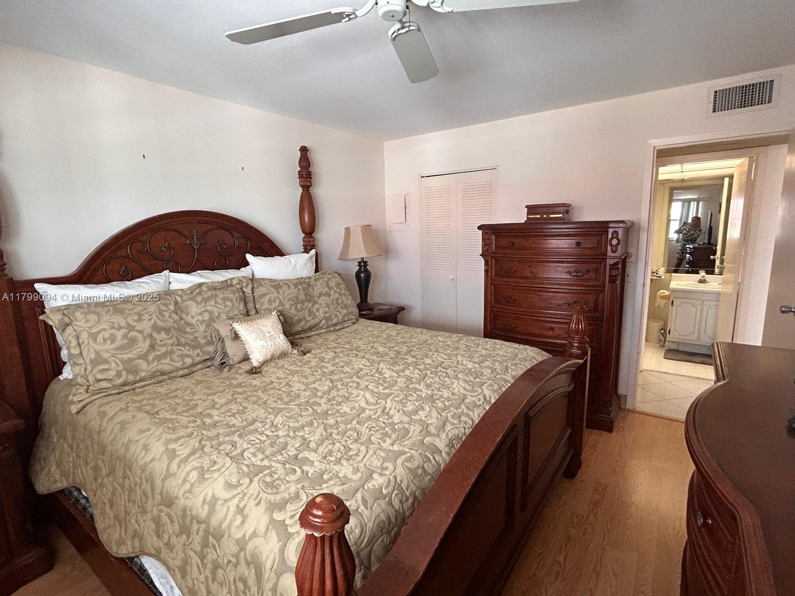 92 Saxony B, Unit B Delray Beach, FL 33446 - Photo 6 of 9 a bedroom with a bed and dresser with mirror