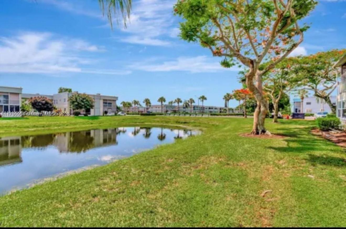92 Saxony B, Unit B Delray Beach, FL 33446 - Photo 9 of 9 a view of a lake with houses in the back