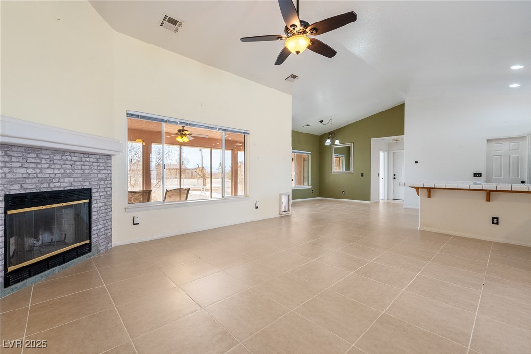 3581 Ranger Way Pahrump, NV 89048 - Photo 8 of 57 living room with light tile patterned floors, ceiling fan, a fireplace, and visible vents