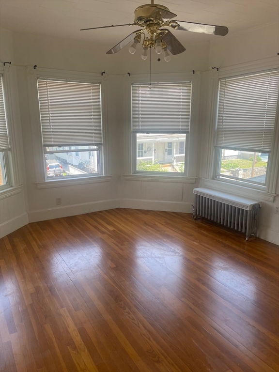 32 Avon Street, Unit 1 Lawrence, MA 01841 - Photo 1 of 4 an empty room with wooden floor and windows