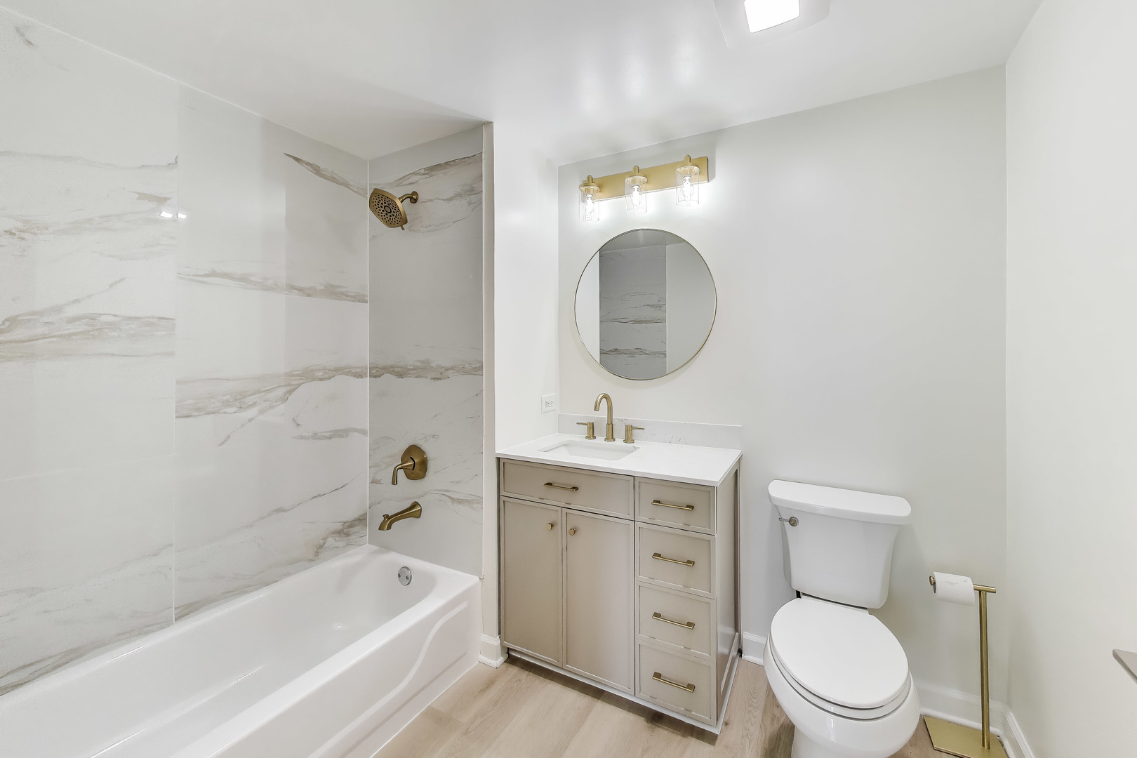 5 East 14th Place, Unit 1405 Chicago, IL 60605 - Photo 19 of 33 a bathroom with a granite countertop toilet a sink and a bathtub