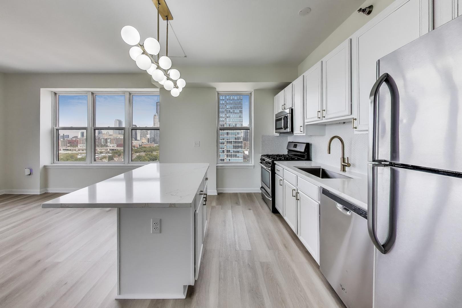 5 East 14th Place, Unit 1405 Chicago, IL 60605 - Photo 10 of 33 a kitchen with stainless steel appliances granite countertop a refrigerator a sink dishwasher a stove and white countertops with wooden floor